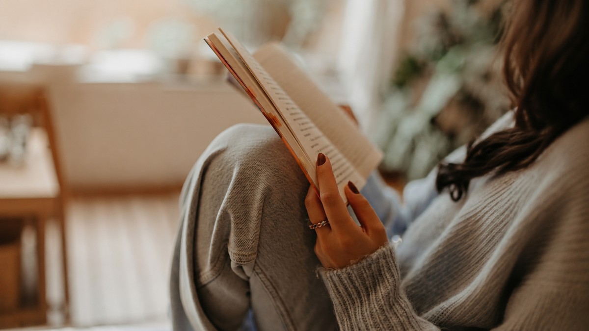Woman reading quietly indoors, representing introspection and honest self-discovery