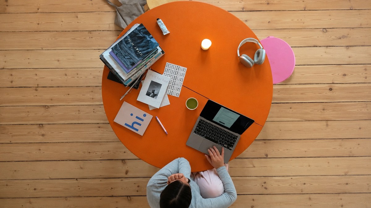 Workspace with a round orange table, representing daily repeated work and routine