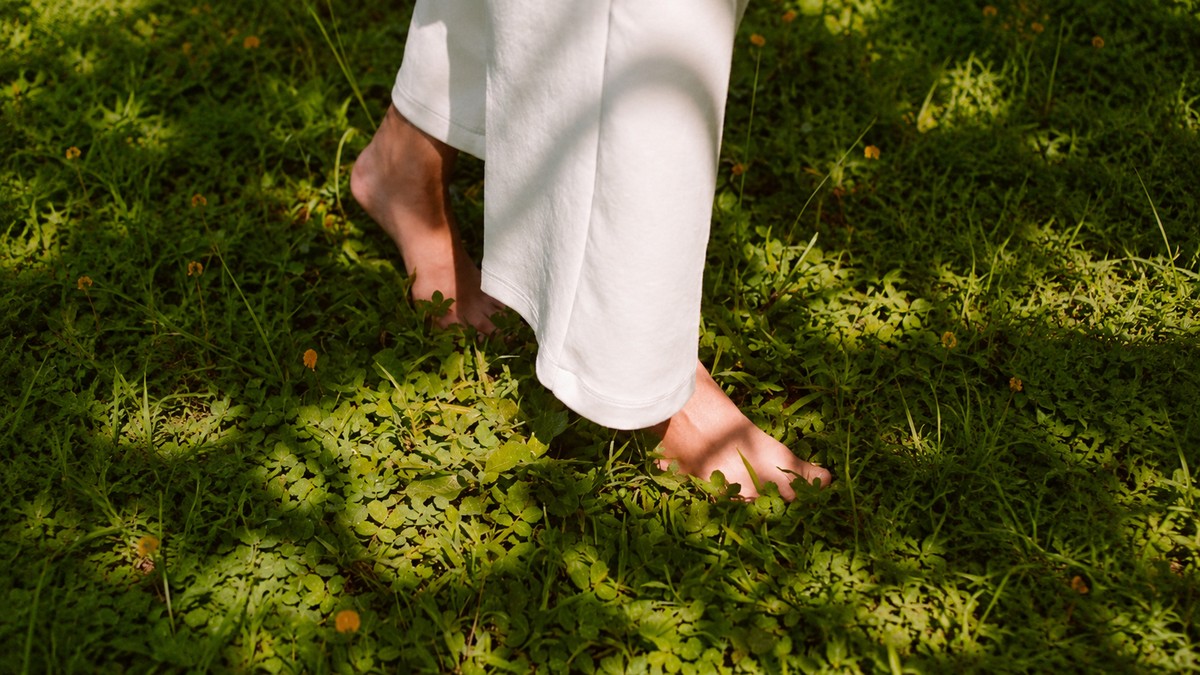 Bare feet standing in grass, representing a gentle, grounded pace of growth